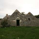 ...punteggiato da due grandi trulli in stato di abbandono su cui capeggiano ben quindici coni